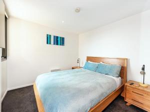 a bedroom with a large bed with blue pillows at City Lifestyle right in the heart of Hobart in Hobart