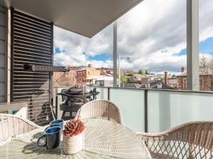 a table and chairs on a balcony with a view at City Lifestyle right in the heart of Hobart in Hobart