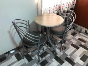 a table and chairs in a room with a checkered floor at Hostal DRABA in Lima