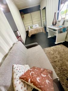ein Wohnzimmer mit einem Sofa und einem Schreibtisch in der Unterkunft Recanto Monte Trigo casa Container in São Francisco do Sul