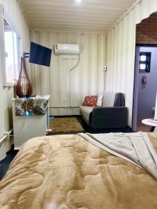サン・フランシスコ・ド・スルにあるRecanto Monte Trigo casa Containerのベッドルーム(大型ベッド1台、ソファ付)