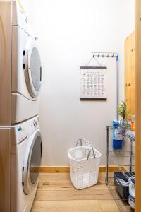 a laundry room with a washing machine and a basket at SmokiesBoutiqueCabins would love to host you! 4 miles to Gatlinburg Strip! Resort Pool open May 1 through Oct 1! Views, Shuffleboard, Hot Tub, Arcade! in Gatlinburg