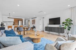 a living room with two couches and a table at Designer Apartment - giant terrace - city location in Hobart