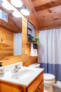 a bathroom with a sink and a toilet at SmokiesBoutiqueCabins would love to host you! 4 miles to Gatlinburg Strip! Resort Pool open May 1 through Oct 1! Views, Shuffleboard, Hot Tub, Arcade! in Gatlinburg