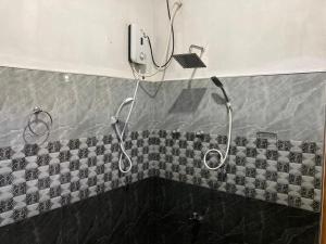 a shower in a bathroom with a tiled wall at Sayura Beach Hotel in Mirissa