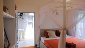 1 dormitorio con 1 cama con dosel en Surf Lodge Madiha, en Matara