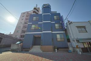 ein blaues Gebäude mit einer Treppe davor in der Unterkunft ホテルよしや in Osaka