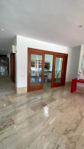 an empty room with wood floors and glass doors at SrvittiniVillas Spacius Confort Villa Fam Team CouplesCasa de Campo Resort in La Romana