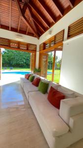 a living room with a white couch with colorful pillows at SrvittiniVillas Spacius Confort Villa Fam Team CouplesCasa de Campo Resort in La Romana