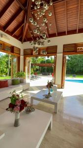 a living room with couches and tables and a pool at SrvittiniVillas Spacius Confort Villa Fam Team CouplesCasa de Campo Resort in La Romana