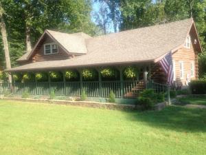 una casa con una bandera americana en el patio delantero en Acorn Resort a Unique Retreat Cabin, 13 acres land, en Bloomington