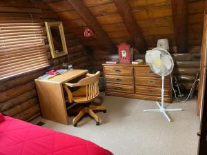 Habitación con escritorio y ventilador. en Acorn Resort a Unique Retreat Cabin, 13 acres land, en Bloomington