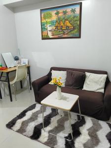 a living room with a couch and a table at 1 BR with poolside view balcony in Manila