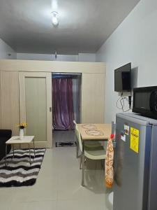 a small kitchen with a table and a refrigerator at 1 BR with poolside view balcony in Manila
