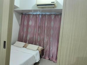 a small room with a bed and a curtain at 1 BR with poolside view balcony in Manila