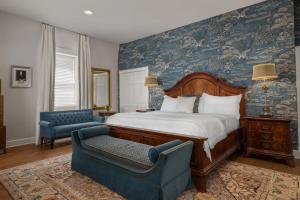 a bedroom with a bed and a couch and a chair at Hamilton Turner Inn in Savannah
