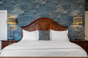 a bedroom with a large bed with blue wallpaper at Hamilton Turner Inn in Savannah