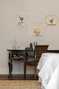 a bedroom with a table and a chair and mirrors at Hamilton Turner Inn in Savannah
