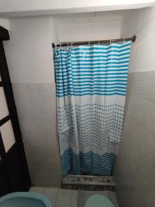eine Dusche mit einem blauen Duschvorhang im Bad in der Unterkunft Hospedaje Casa Versalles in Villa de Leyva