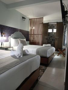 ein Hotelzimmer mit 2 Betten und einem Tisch in der Unterkunft Añoranza Hotel Boutique in Ciudad Hidalgo