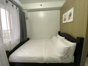 a bedroom with a bed with white sheets and pillows at SHORE RESIDENCE D18 shortwalk Mall of asia near airport in Manila