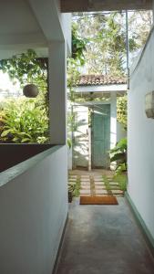 a hallway of a house with a door and plants at Surf Lodge Madiha in Matara
