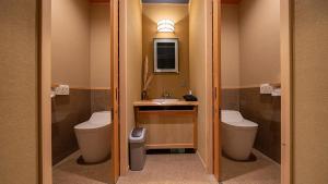 a bathroom with two toilets and a sink at WAT RESORT 飛騨まちやど 藤 in Takayama