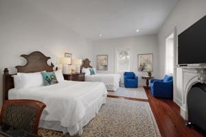 a bedroom with two beds and a fireplace at Hamilton Turner Inn in Savannah