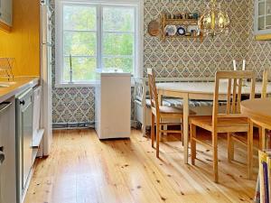 a kitchen and dining room with a table and chairs at 6 person holiday home in LOFTAHAMMAR-By Traum in Loftahammar +13 photos