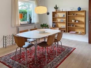 Holiday home Tønder III في توندر: غرفة طعام مع طاولة وكراسي على سجادة