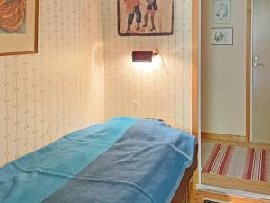 Cette chambre comprend un lit avec une couverture bleue. dans l'établissement Holiday home Vingåker III, à Vingåker