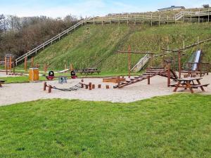 a playground with wooden benches and a slide at Holiday home Lemvig XLVII in Lemvig