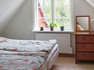 1 dormitorio con 1 cama con tocador y ventana en Holiday home HISHULT III, en Hishult