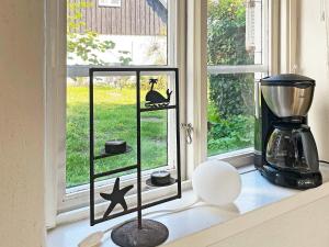 alféizar de la ventana con dos estanterías con un pájaro y una licuadora en Holiday home SKILLINGE II, en Skillinge