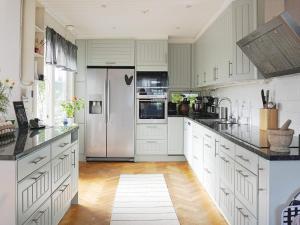 eine Küche mit weißen Schränken und einem Kühlschrank in der Unterkunft Holiday home ENSKEDE in Stockholm