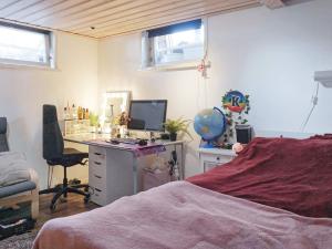 Schlafzimmer mit einem Schreibtisch, einem Computer und einem Bett in der Unterkunft Holiday home ENSKEDE in Stockholm
