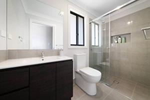 a bathroom with a toilet and a sink and a shower at Relaxing Two-Level Retreat in Austral, NSW in Austral +6 photos