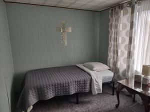 een slaapkamer met een bed en een kruis aan de muur bij Sunset Place in Conneaut