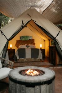 a tent with a bed with a fire in it at Cozy Unique Glamping on 53 acres - Bedrock Site in Branson