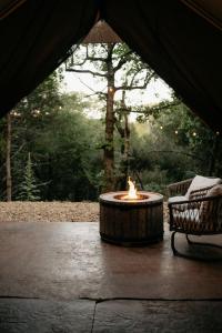 ブランソンにあるCozy Unique Glamping on 53 acres - Bedrock Siteのテント内の炉(椅子2脚付)