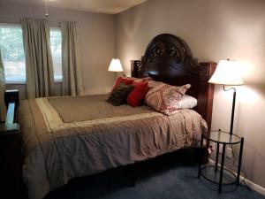 a bedroom with a bed with pillows and two lamps at Midtown Southern Charm in Tyler