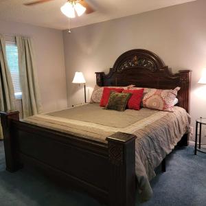 a bedroom with a large bed with red pillows at Midtown Southern Charm in Tyler