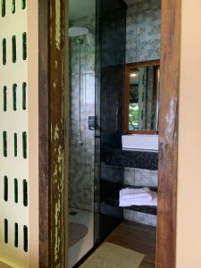 a bathroom with a shower with a sink and a mirror at Paraíso das Tartarugas in Bombinhas