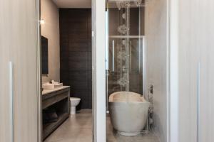 a bathroom with a bath tub and a toilet at Laviu B&B Luxe Suites in Puebla