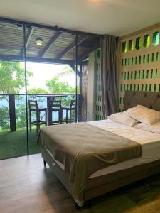 1 dormitorio con 1 cama grande y balcón en Paraíso das Tartarugas, en Bombinhas