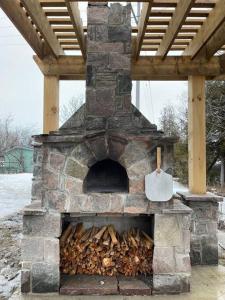 Un horno de piedra con un montón de madera. en Lambs Landing, en Fenelon Falls