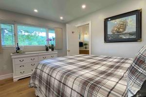 een slaapkamer met een bed met een geruite deken bij Lambs Landing in Fenelon Falls