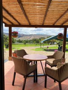een tafel en stoelen op een patio met uitzicht bij Cabañas Villa Celeste in Villa de Leyva