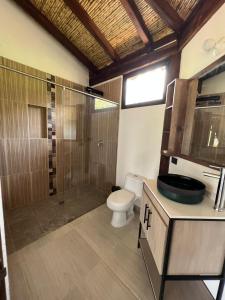 y baño con aseo, ducha y lavamanos. en Cabañas Villa Celeste en Villa de Leyva