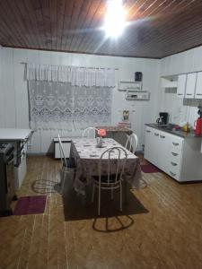 a kitchen with a table and chairs in a room at Casa de madeira em local tranquilo in Mafra